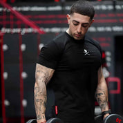 Model wearing black Summer Men’s Cotton Gym T-Shirt while lifting weights in the gym, showcasing comfort and flexibility.