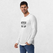 Model wearing the White GPW Never Give Up Performance Long Sleeve Tee with jeans in a studio background.