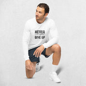 Sitting Model wearing the White GPW Never Give Up Performance Long Sleeve Tee with jeans in a studio background.