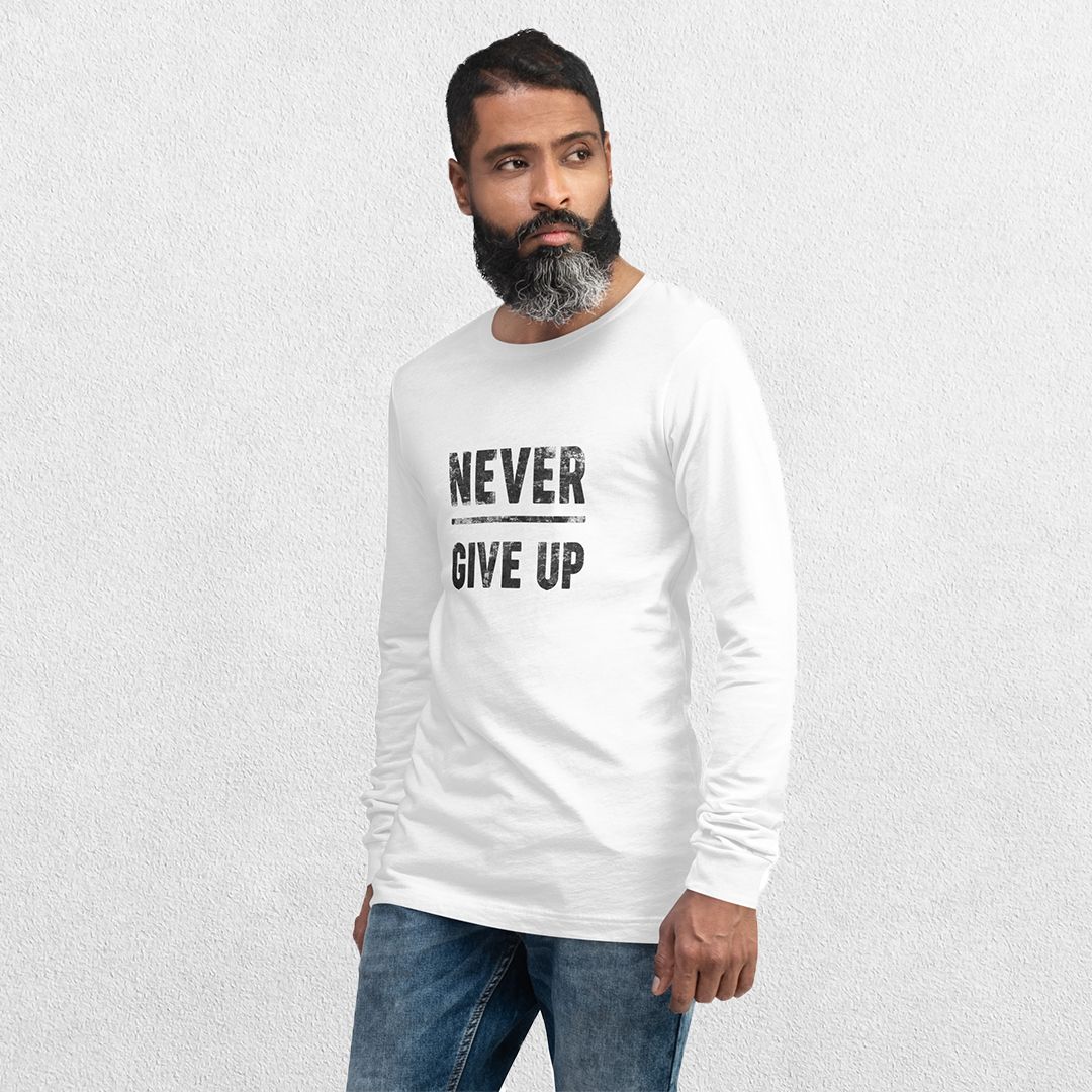 Model wearing the White GPW Never Give Up Performance Long Sleeve Tee with jeans in a studio background.