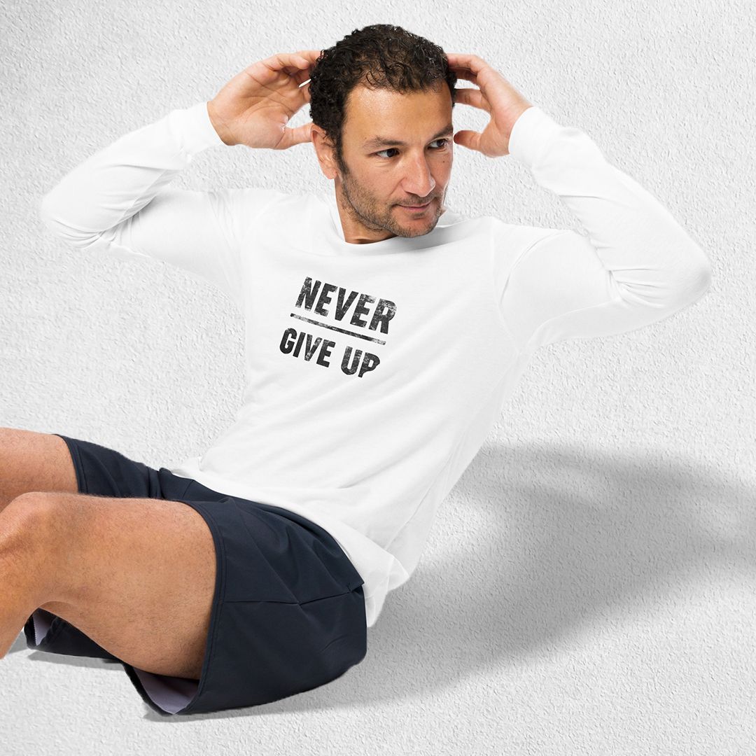 Exercising Model wearing the White GPW Never Give Up Performance Long Sleeve Tee with jeans in a studio background.