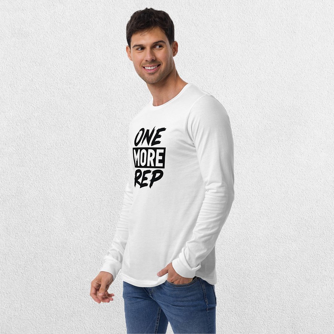Model wearing the White GPW One More Rep Unisex Motivational Long Sleeve Tee with jeans in studio background.