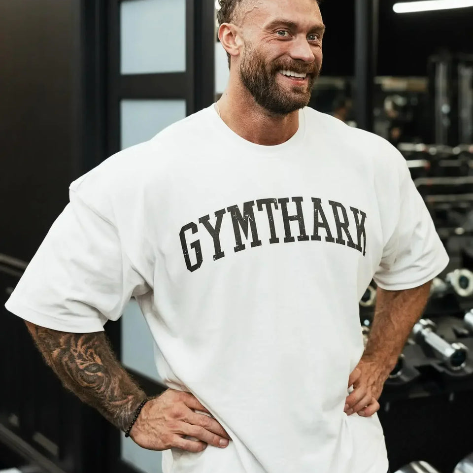 Side View of Model Wearing White Loose Fit Oversized Gym Tee – Heavyweight Cotton, Premium Comfort & Strength in a gym
