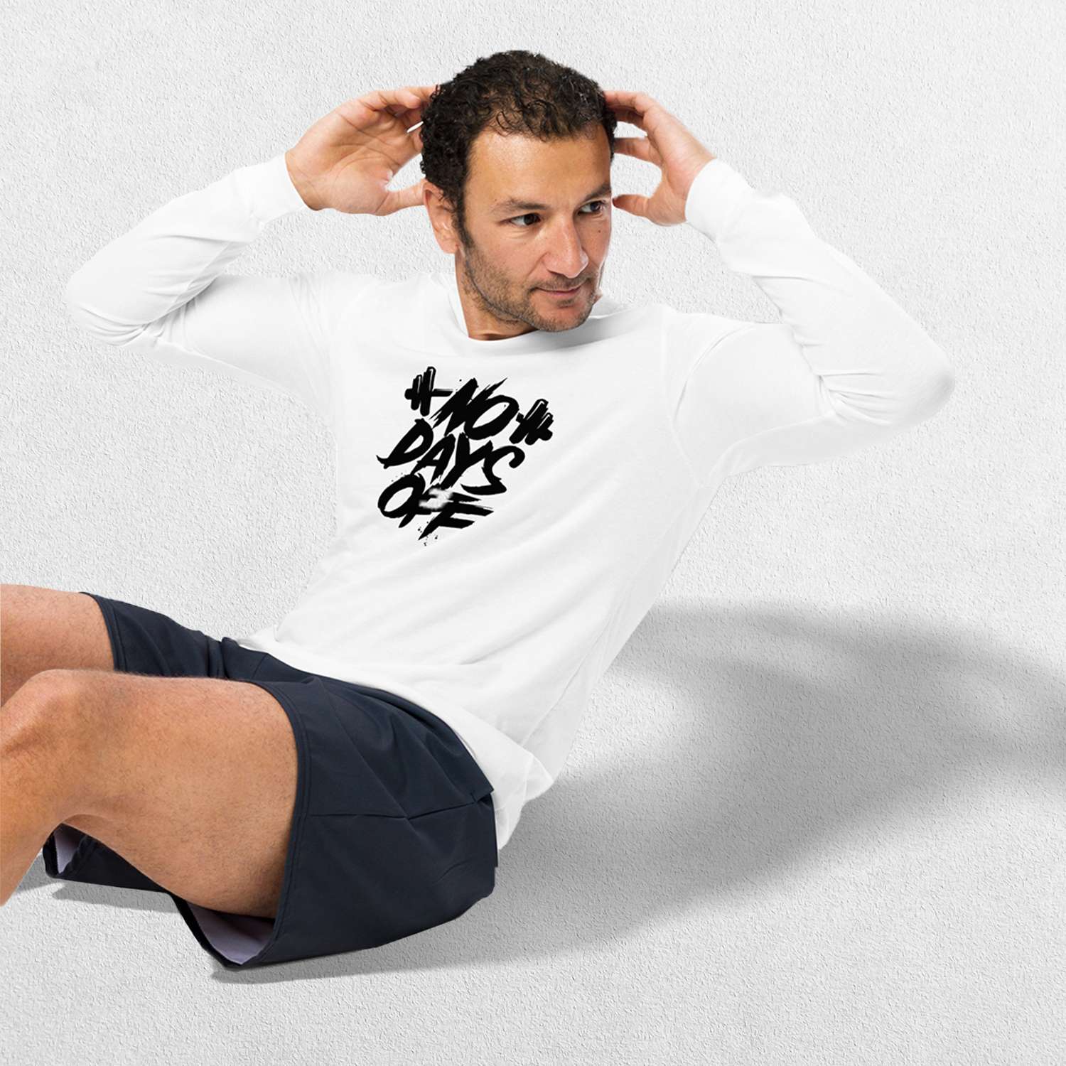 Streching Model wearing the White No Days Off Unisex Long Sleeve Tee - Versatile Athletic and Casual Wear in studio background