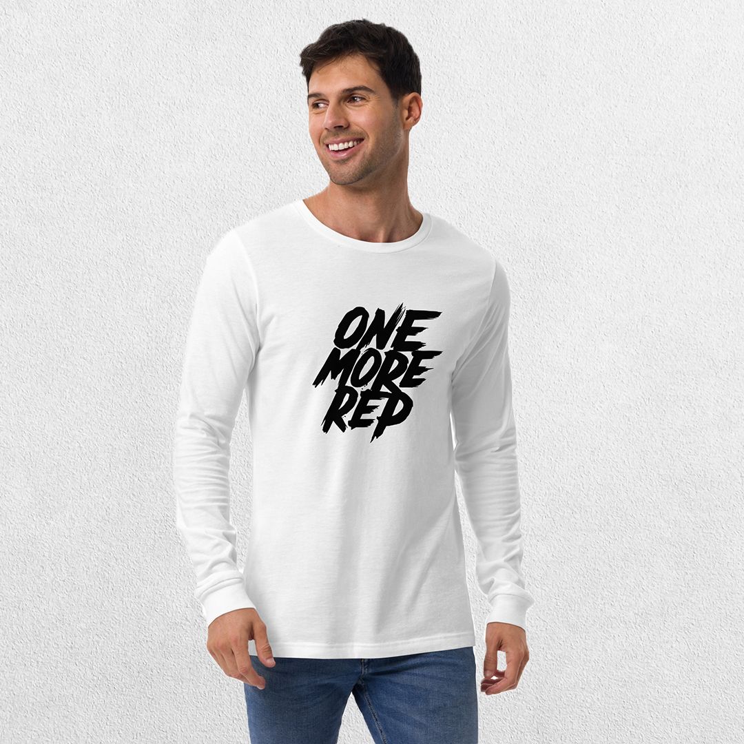 Model wearing the White One More Rep High-Performance Long Sleeve Tee – Unisex Gym Wear with jeans in a studio background.