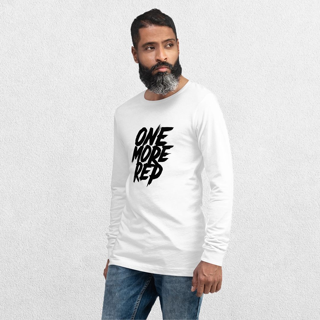 Model wearing the White One More Rep High-Performance Long Sleeve Tee – Unisex Gym Wear with jeans in a studio background.