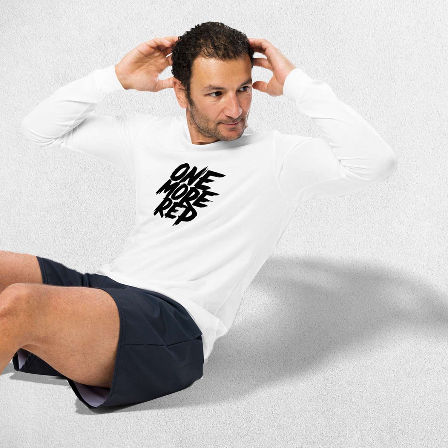 Exercising Model wearing the White One More Rep High-Performance Long Sleeve Tee – Unisex Gym Wear in a studio background.