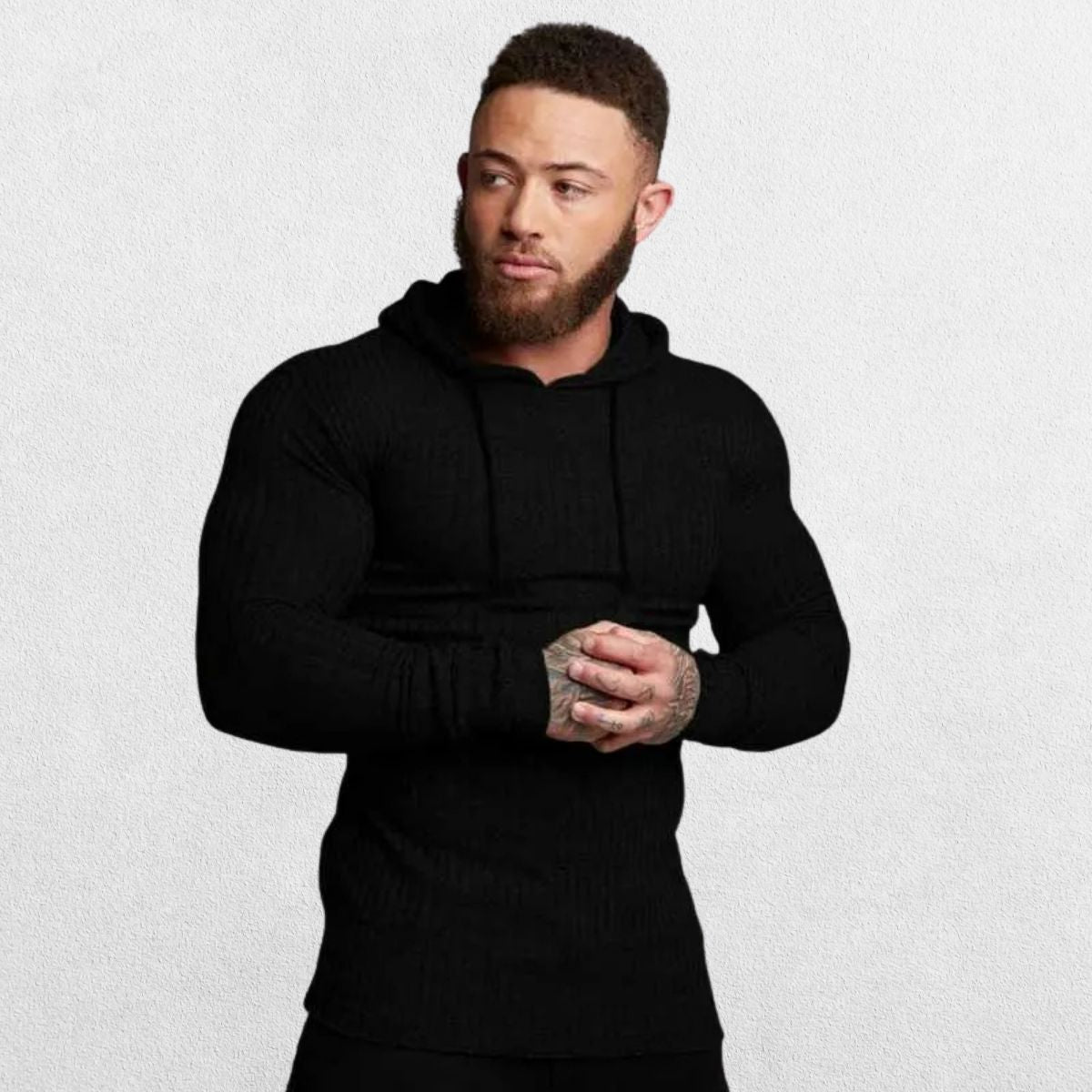 Model wearing black Men’s Slim Fit Sport Hoodie in front of a black studio background, showcasing its sleek design.