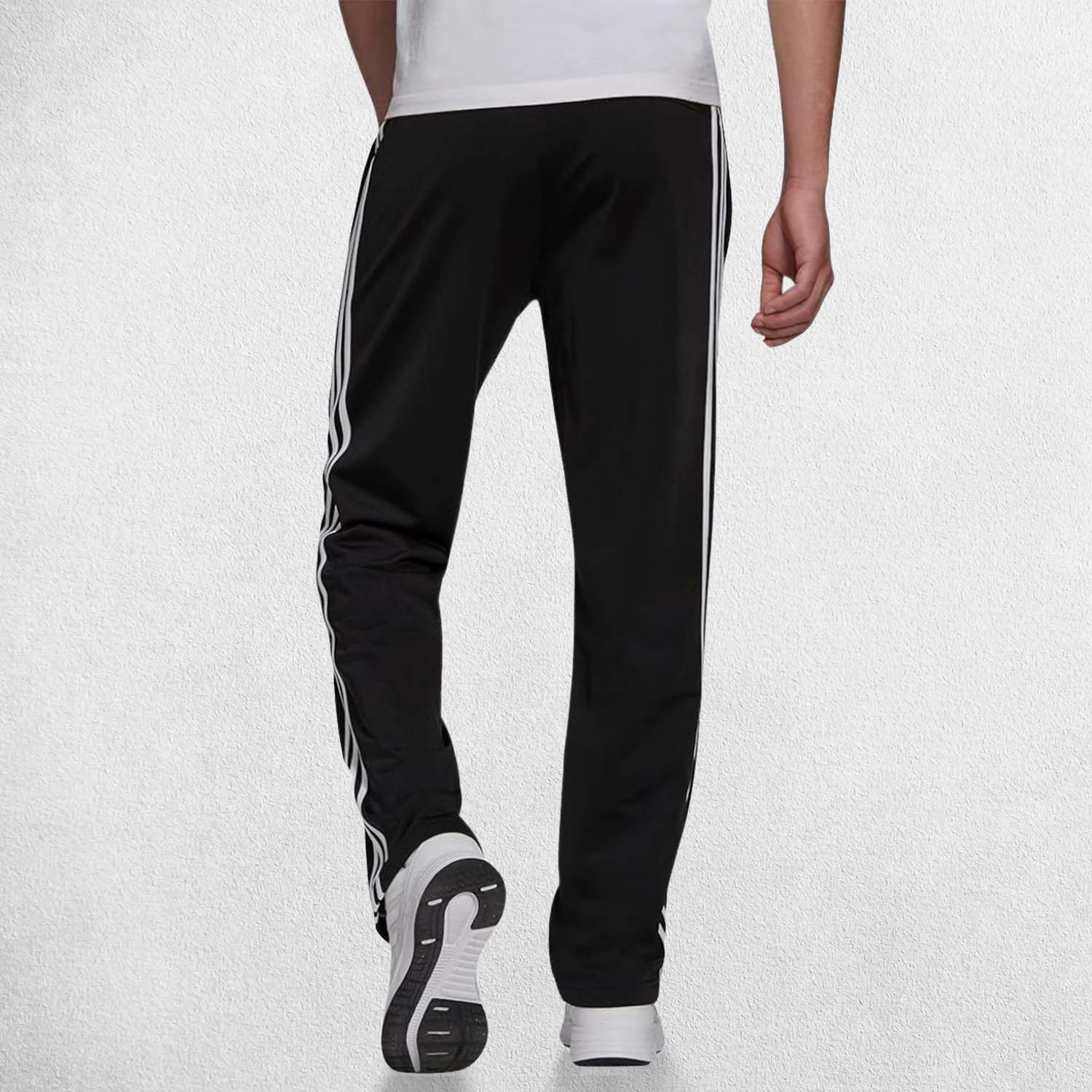 Back pose of Model Wearing Black 3-Stripes Tracksuit Pants made with Primegreen fabric