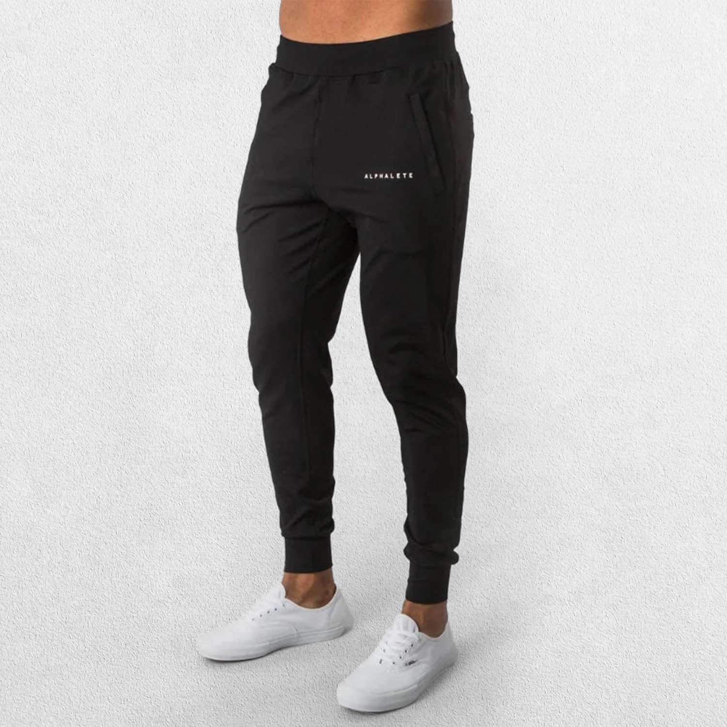 A man stretching in Black GPW athletic trousers, showcasing flexibility and comfort.