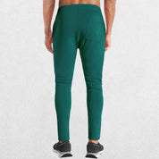 GPW Men’s Slim Fit Zip Athletic Pants Dark Green Back View in Studio Background
