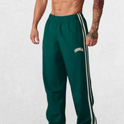Durable double-stitching and bold printed design on green sports pants.