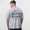 Back view of Model Wearing Light Grey Men’s Barbell Brigade Cotton Workout Tee with bold print
