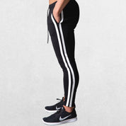 Side profile of Men’s Striped Joggers in black, highlighting the sporty striped design and tapered leg.