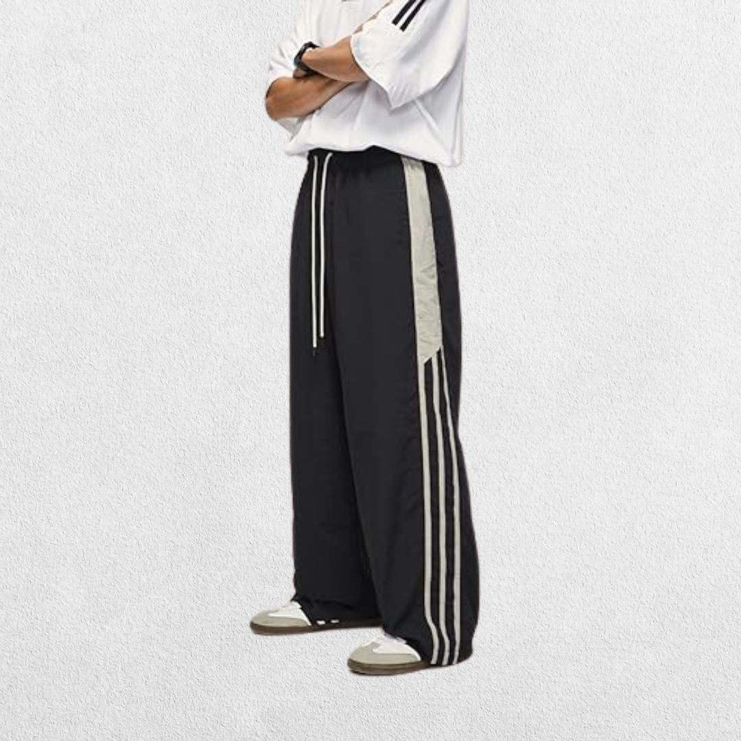 Streetwear-inspired black baggy Y2K trousers with hands in pockets, perfect for a retro casual outfit