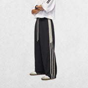Streetwear-inspired black baggy Y2K trousers with hands in pockets, perfect for a retro casual outfit