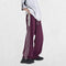 Model wearing Unisex Y2K Trousers in purple with a vintage baggy fit and elastic waistband, styled for a retro streetwear look, captured from a side profile.