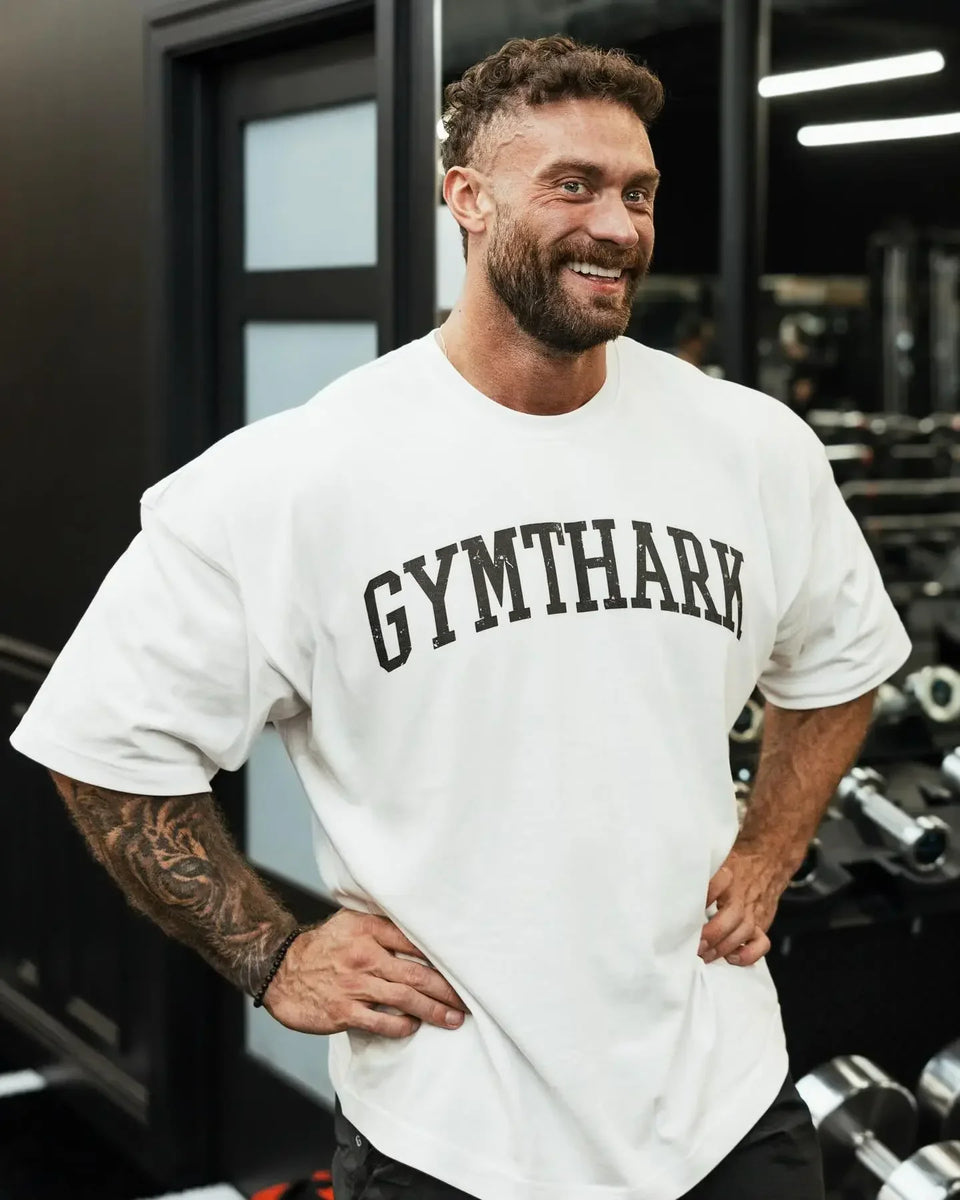 Side View of Model Wearing White Loose Fit Oversized Gym Tee – Heavyweight Cotton, Premium Comfort & Strength in a gym